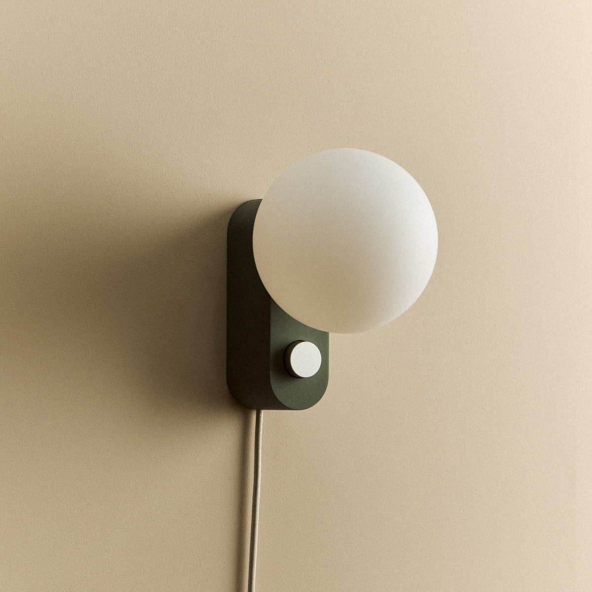 Alumina Lamp in Sage mounted on a wall, unlit