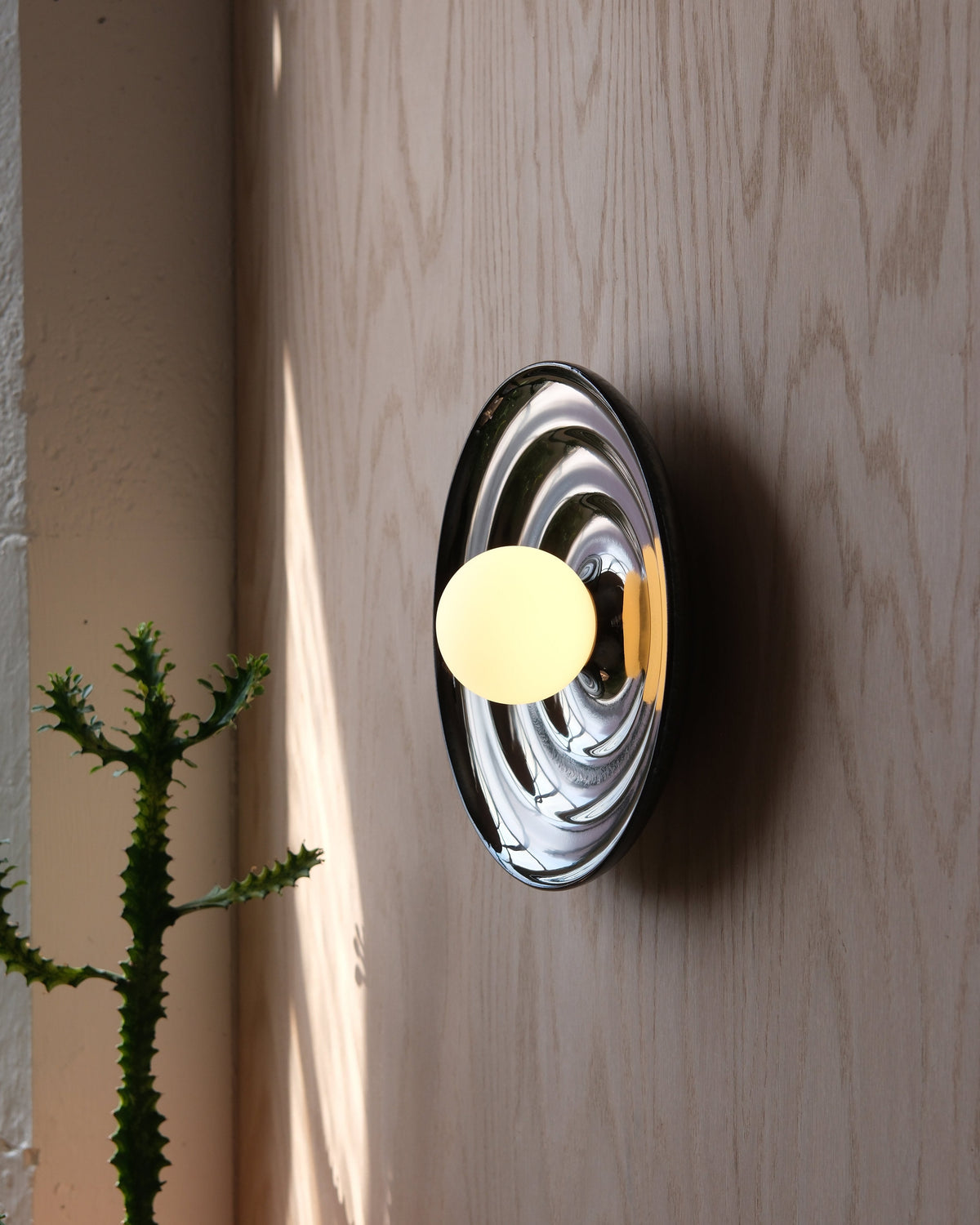 Ripple Bowl Sconce in Chrome on a wood wall