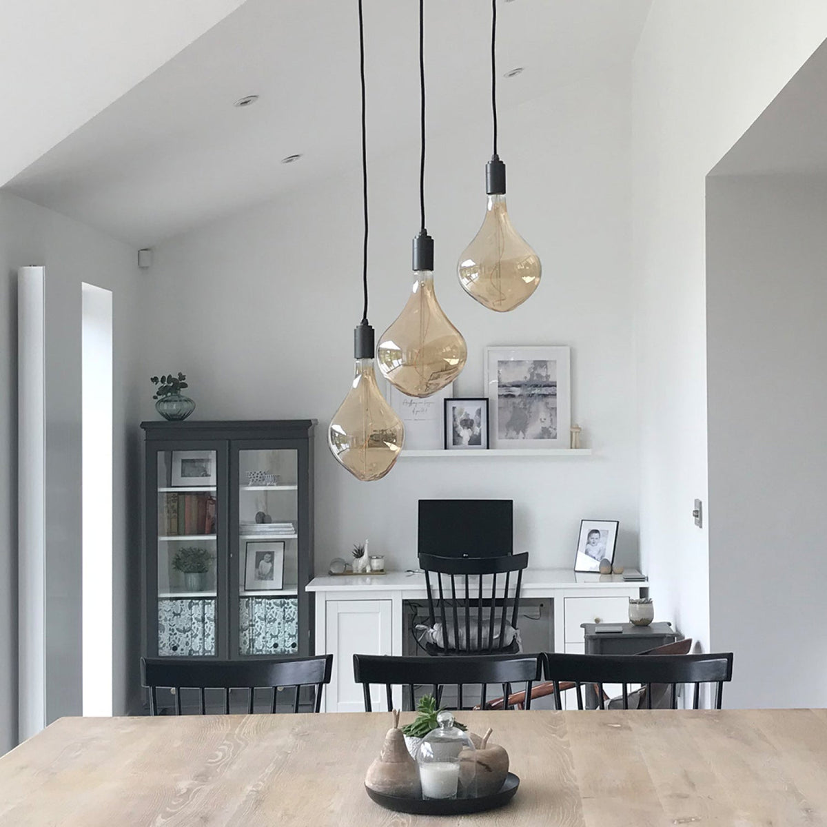 Three Voronoi II Pendant Lights in Graphite at staggered heights over a dining table