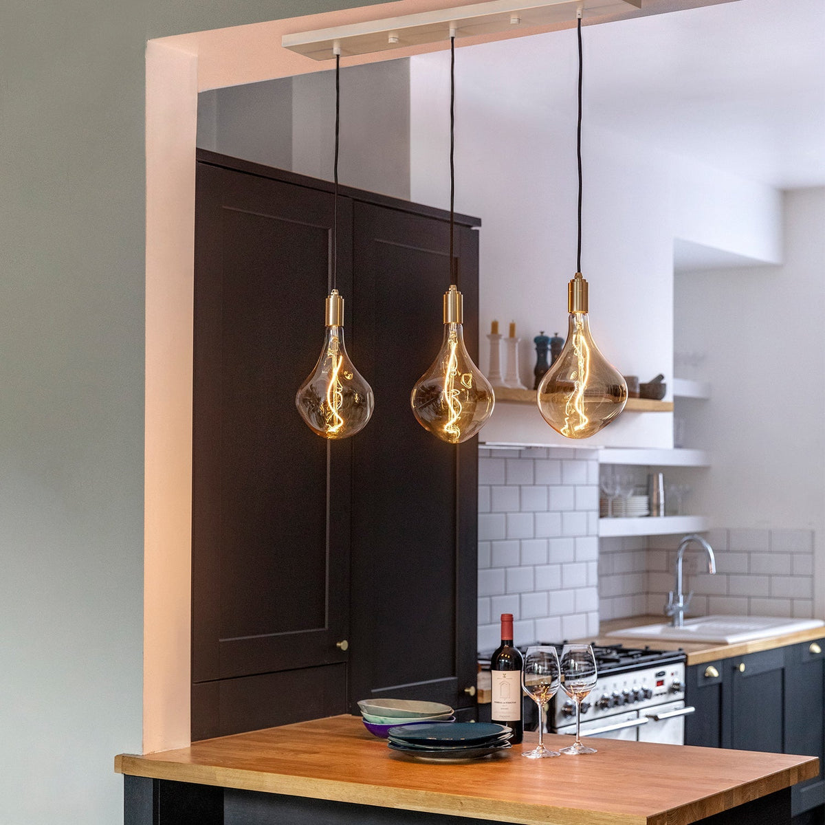 Voronoi II Linear Triple Pendant in Brass over a kitchen counter
