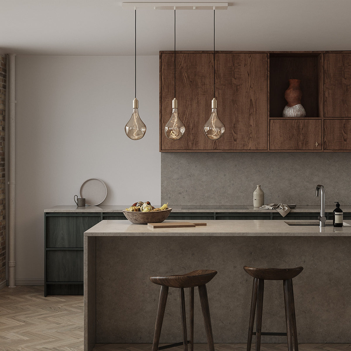 Voronoi II Linear Triple Pendant in Brass over a kitchen island with stools