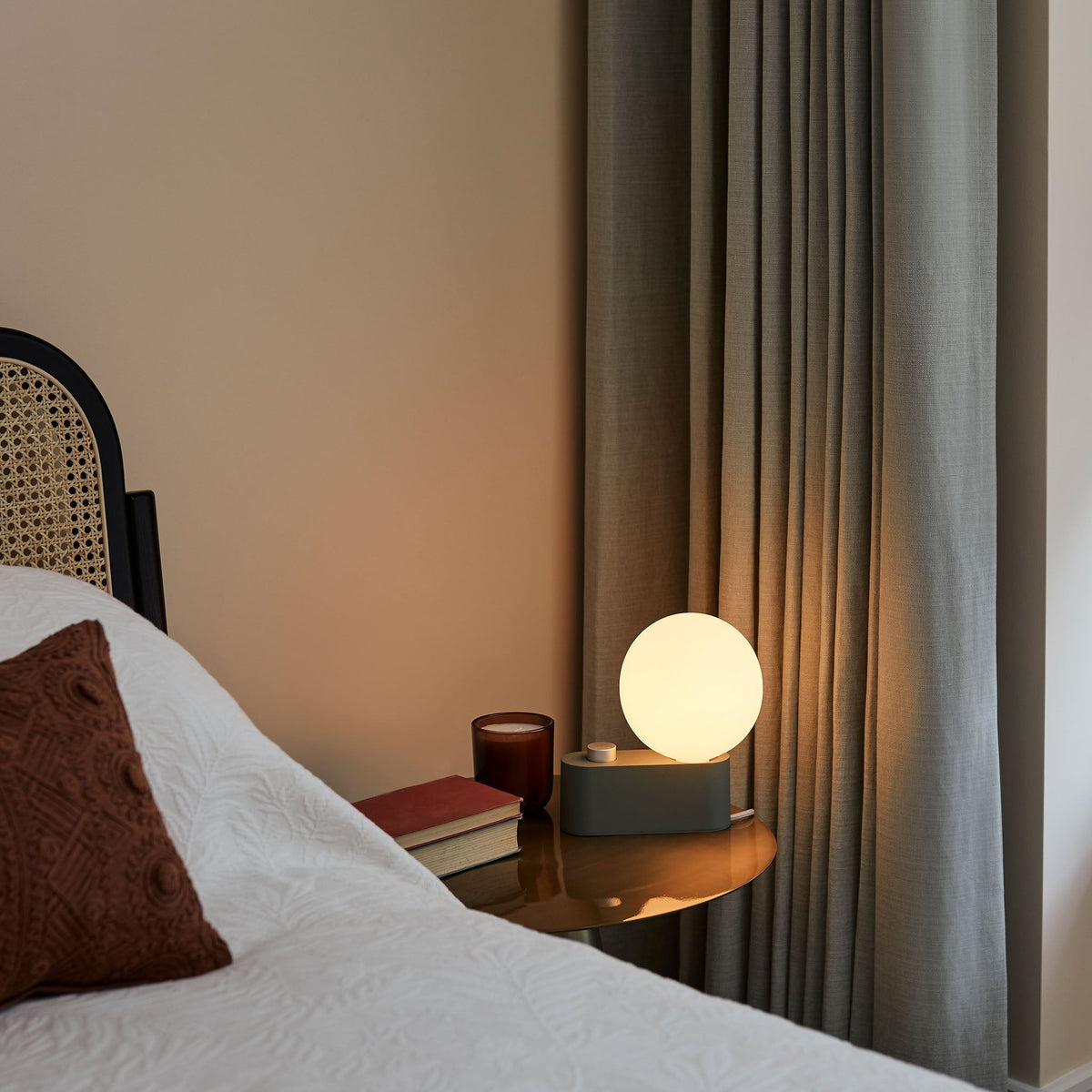 Alumina Lamp in Sage on a bedside table