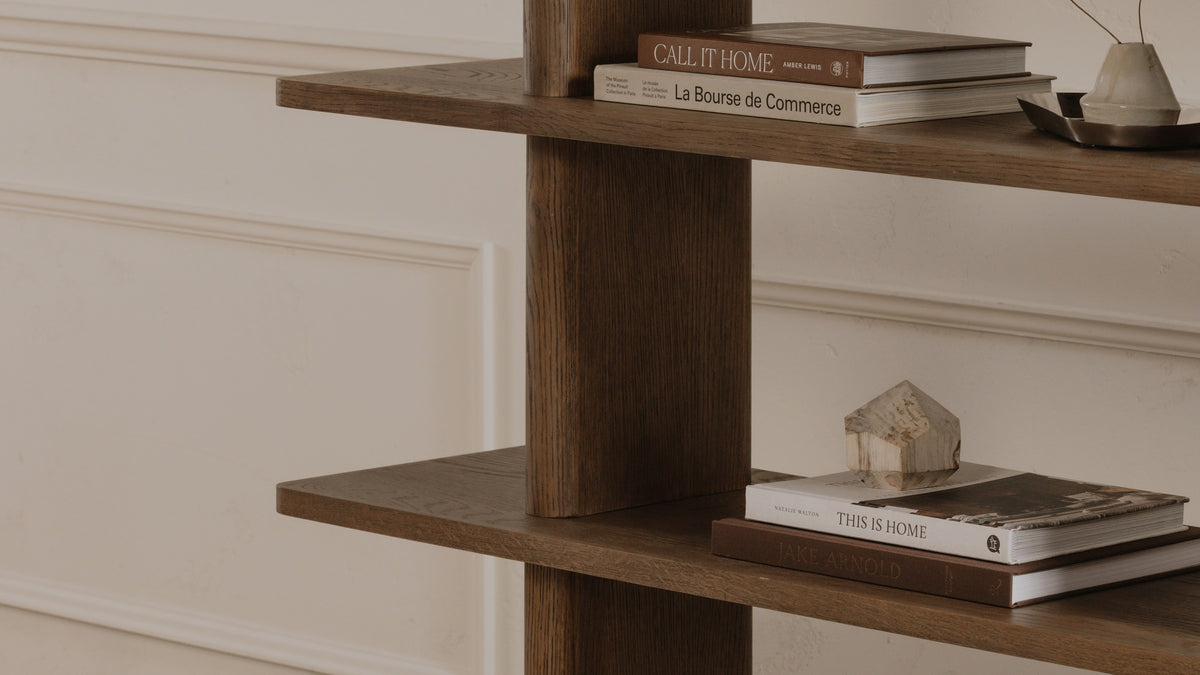 Moe's Home Collection Casey Large bookcase in dark brown oak, close enough to see the shelf ends and where each shelf meets the upright, with books above