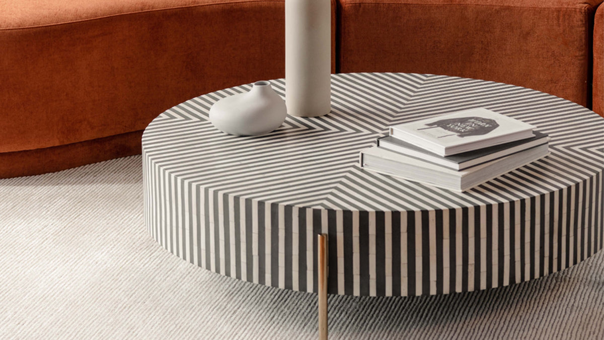 Moe's Home Collection Chameau round coffee table seen close, the black and white bone veneer stripes running vertically around the drum and meeting in nested right angles across the top
