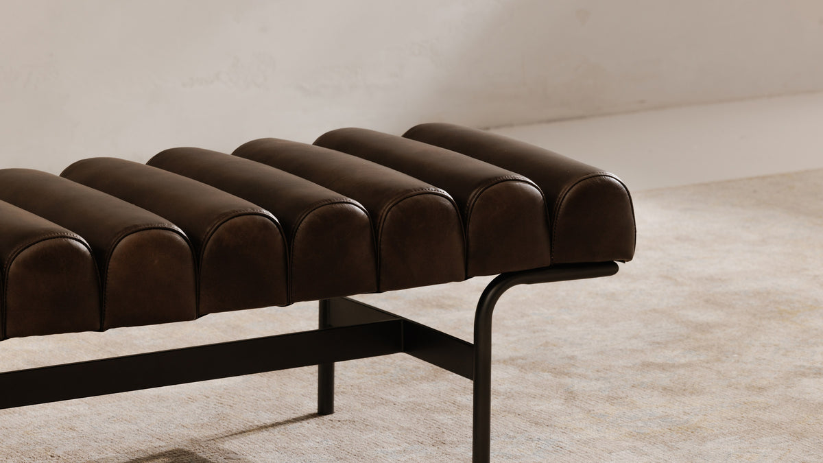 Close view of the Harrison bench in dark brown leather, showing the rounded leather channels and the black iron frame