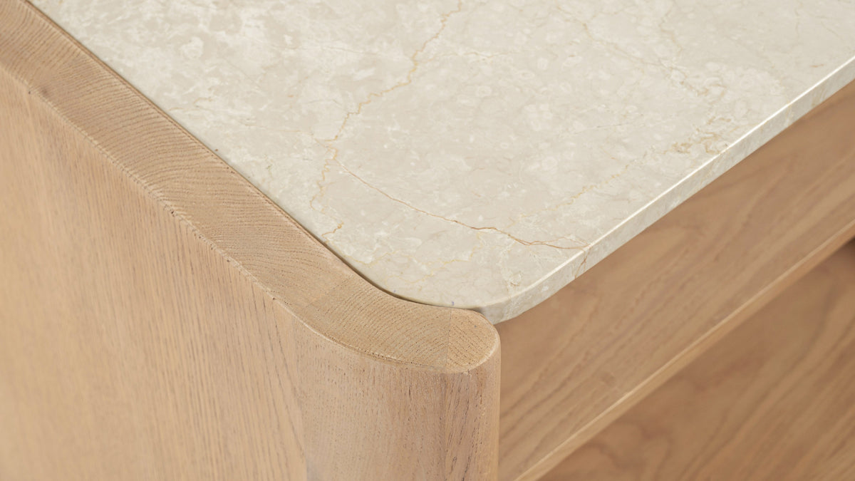 Close detail of the Moe's Home Collection Lane nightstand, the veined Bottichino marble top sitting inset within the rounded solid oak corner post