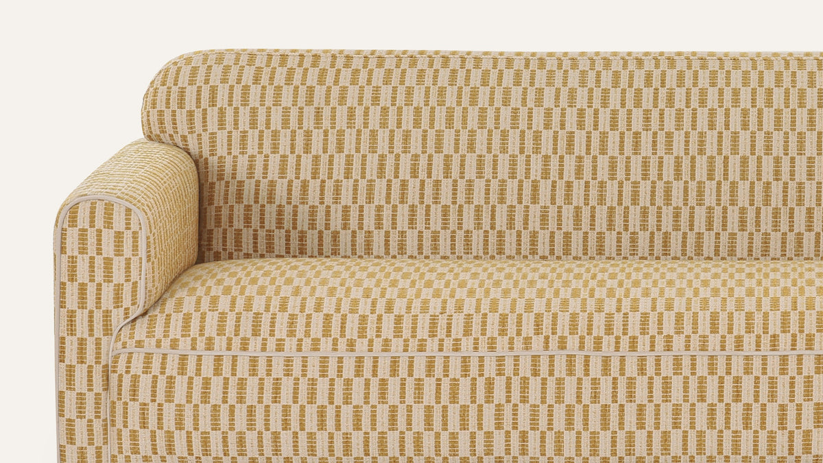 Close view of the Leo sofa in Chartreuse, showing the gold and cream checkerboard weave across the arm and the single bench cushion