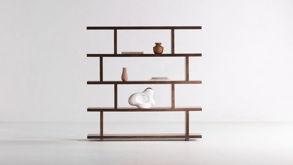 Moe's Home Collection Miri Large bookshelf in walnut, five planks stepping across two uprights to a square elevation, holding a terracotta vase, books and a white sculptural form