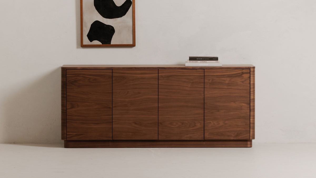 Moe's Home Collection Round Off sideboard in walnut brown against a pale wall, its rounded corners and four doors below a framed abstract print