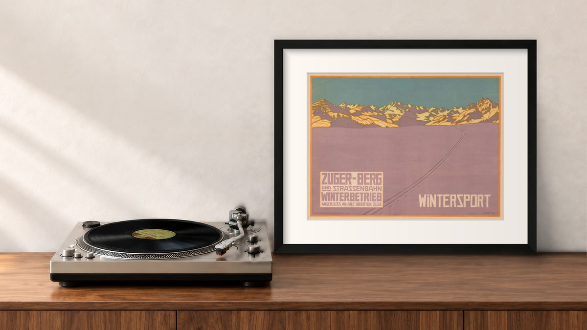 Wintersport Framed Print in a black frame, leaning on a walnut console beside a turntable