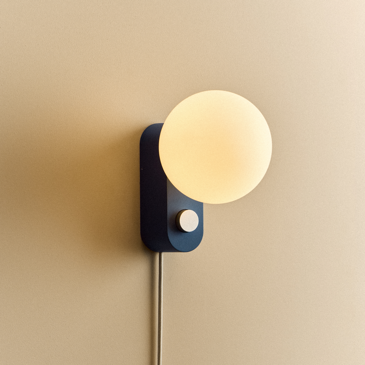 Alumina Lamp in Sapphire mounted on a wall, lit