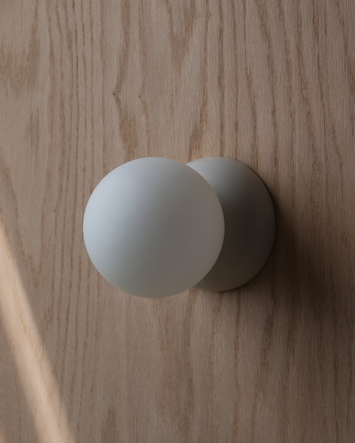 Monroe Sconce in White Matte on a wood wall