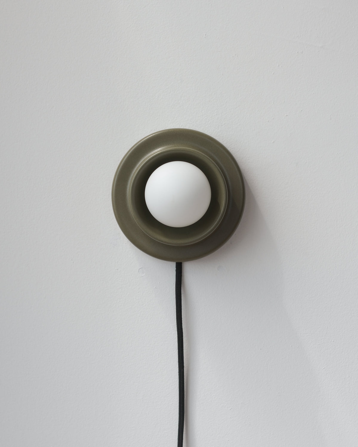 Q Sconce in Moss with its plug-in cord