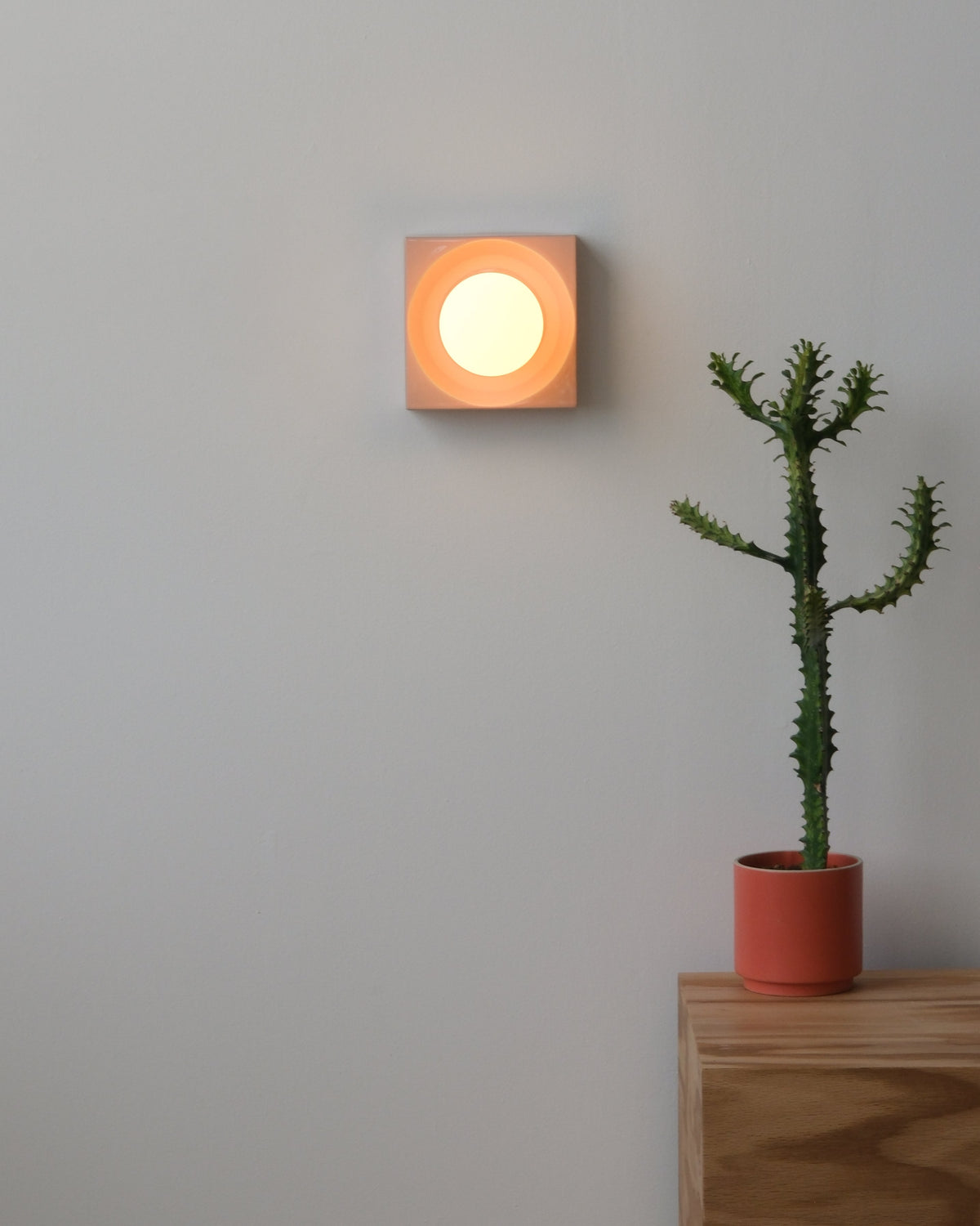 Cubic Sconce in Pink Glossy, lit, room setting