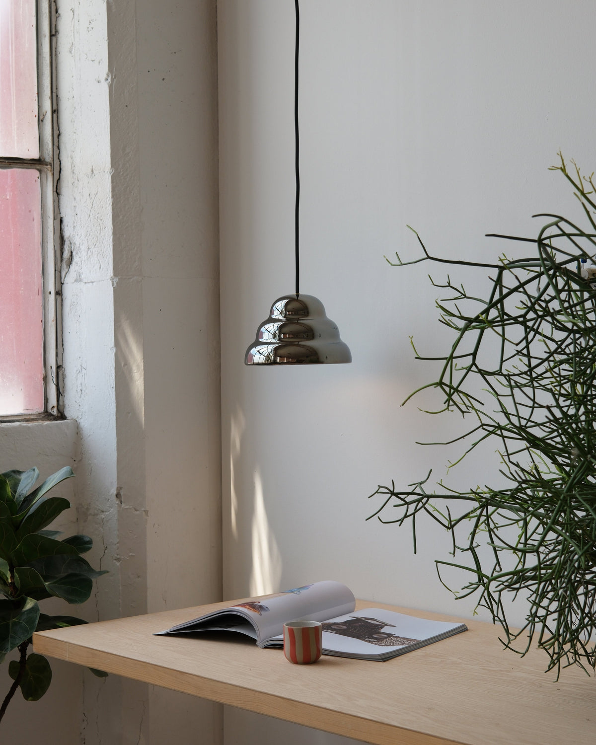 Ripple III Pendant in Chrome over a wall shelf