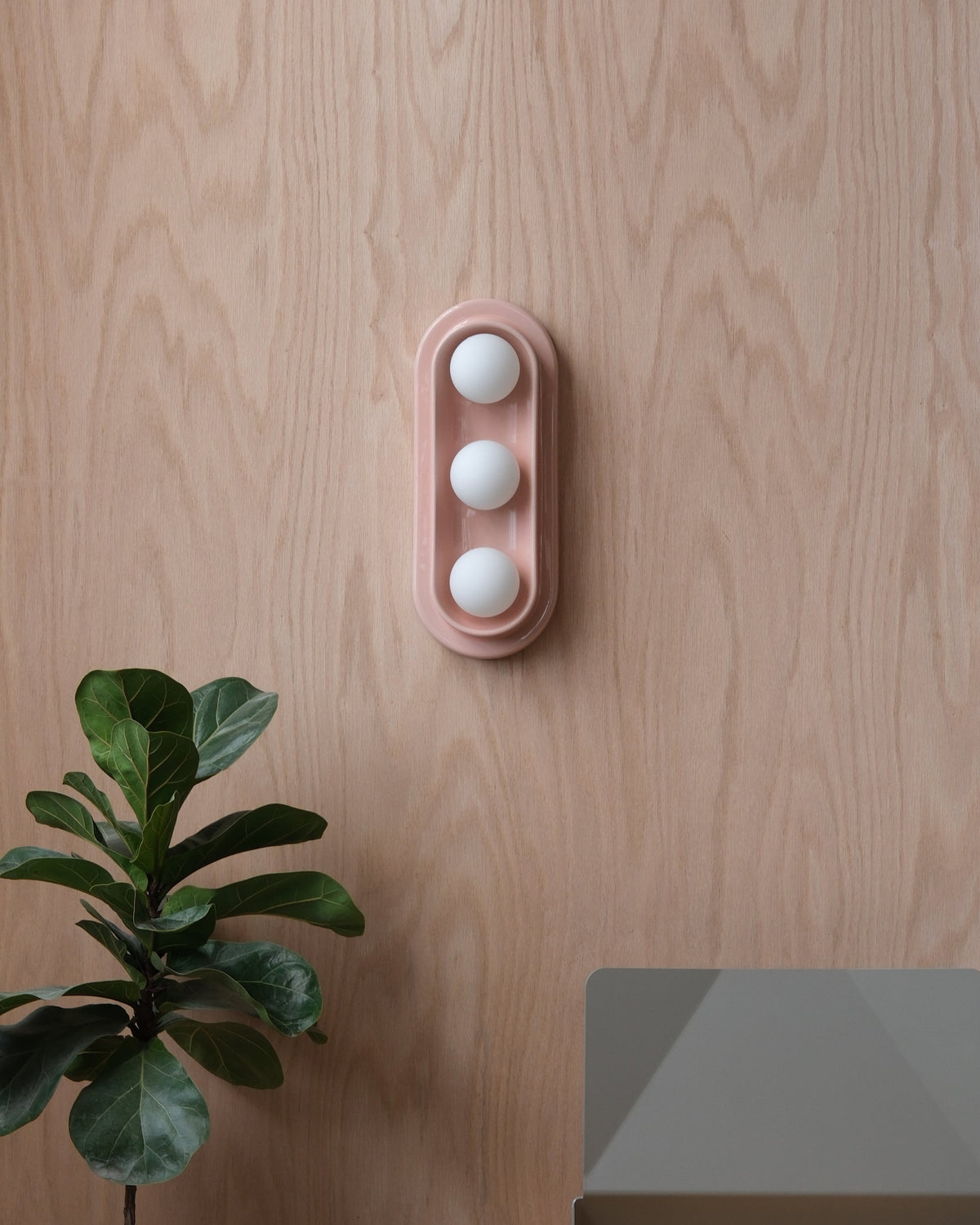 Q Triple Sconce in Pink Glossy on a wood wall