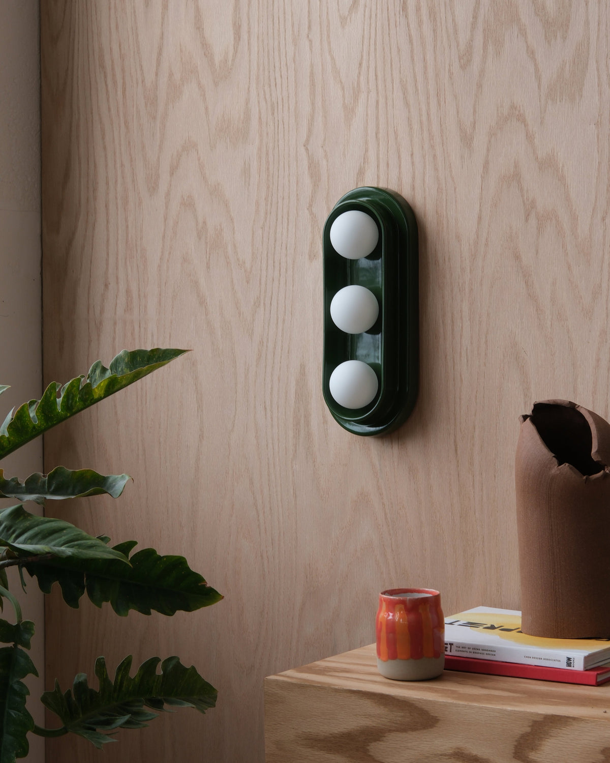 Q Triple Sconce in Green on a wood wall