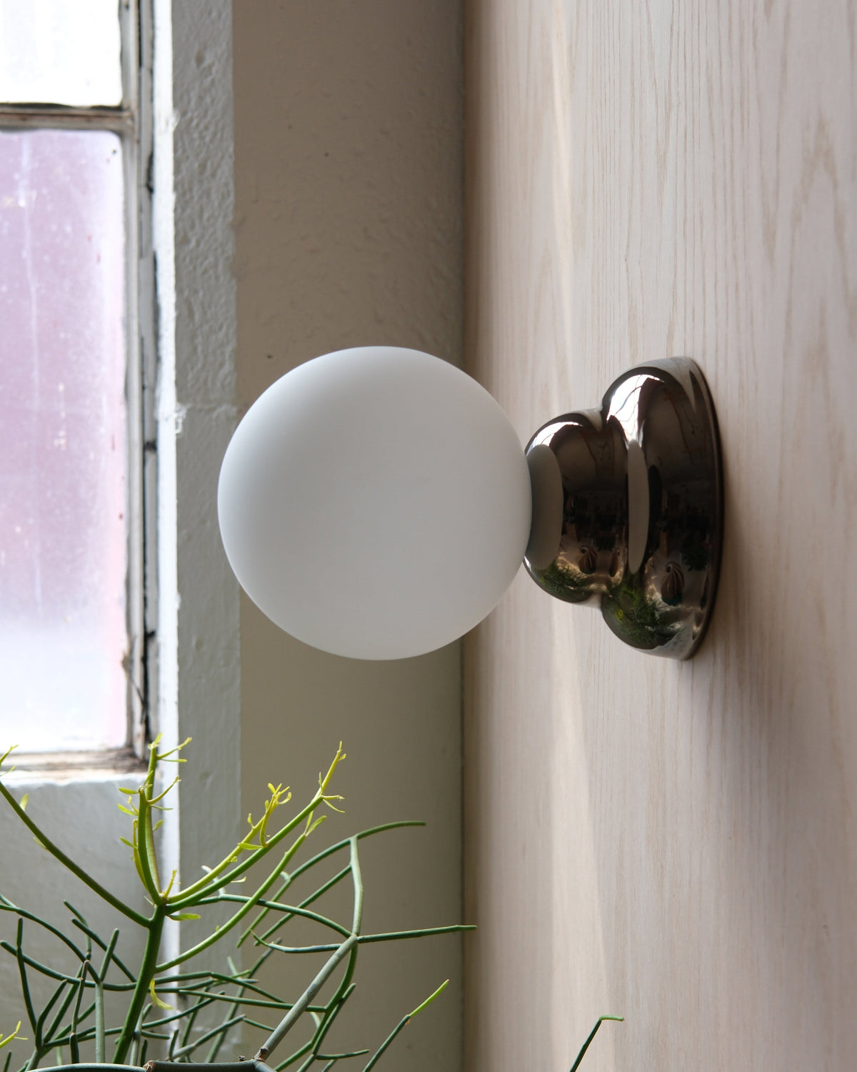 Ripple II Sconce in Chrome on a wood wall
