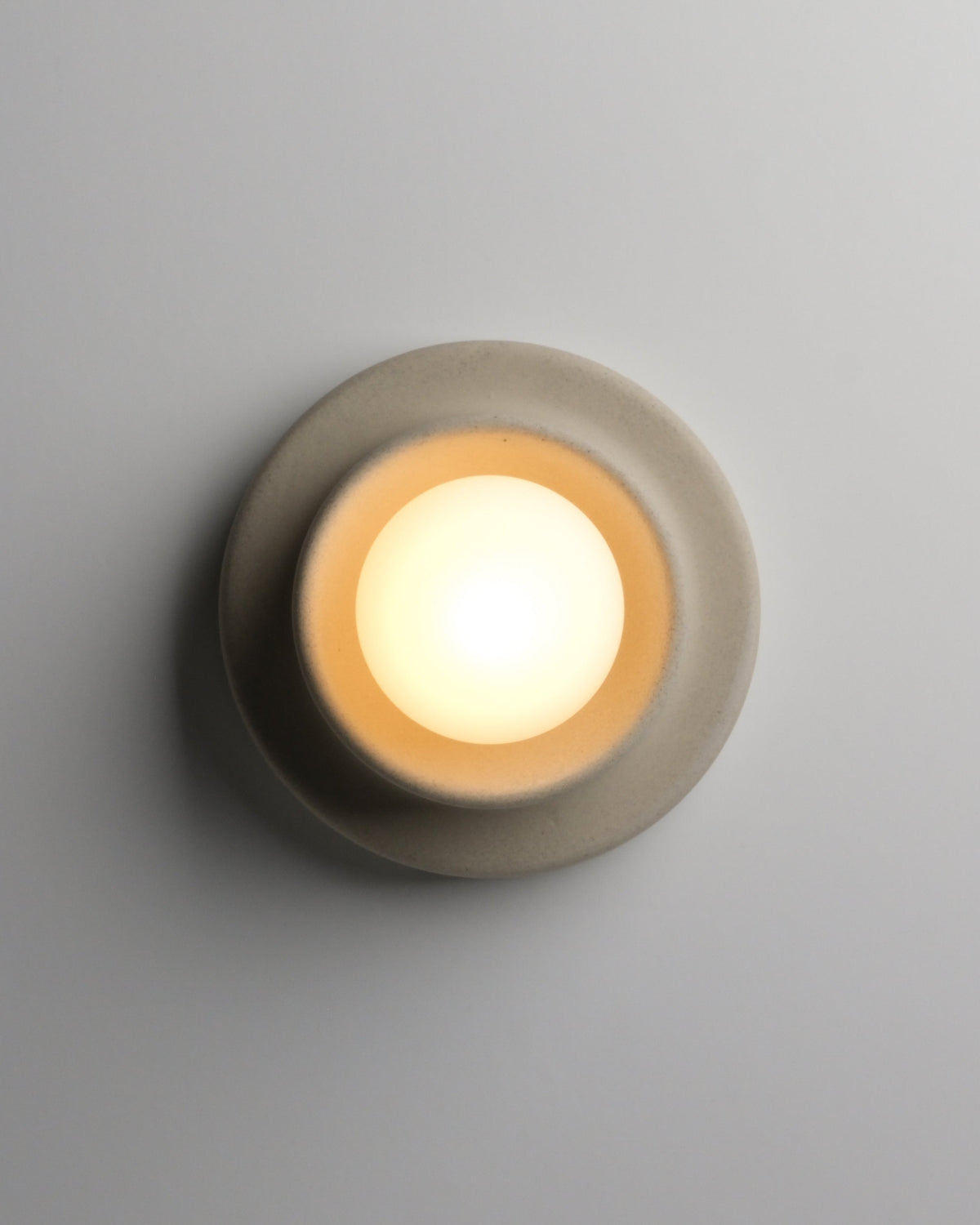 Q Sconce in Dune, lit