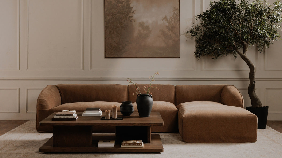 Moe's Home Collection Casey coffee table in the Large size, dark brown oak with two L-shaped supports and an open lower shelf, on a pale rug before a caramel sectional in a panelled room