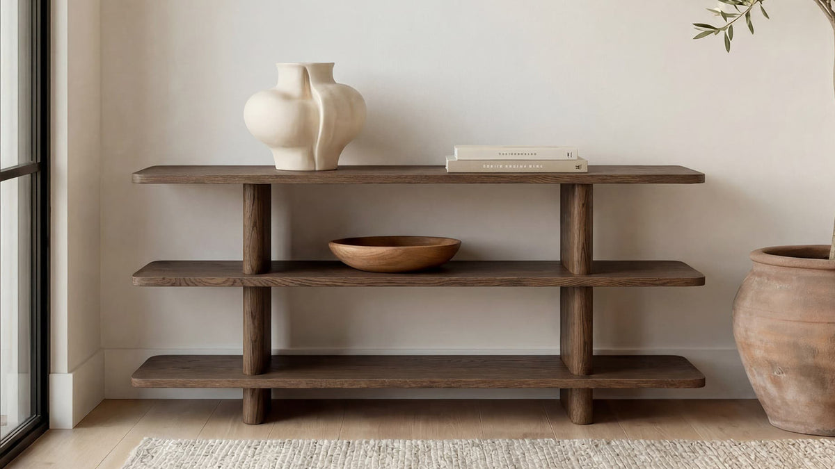Moe's Home Collection Casey Small bookcase in dark brown oak, three shelves stepping low and wide between two solid uprights, holding a wooden bowl, a tall vase and a floor basket