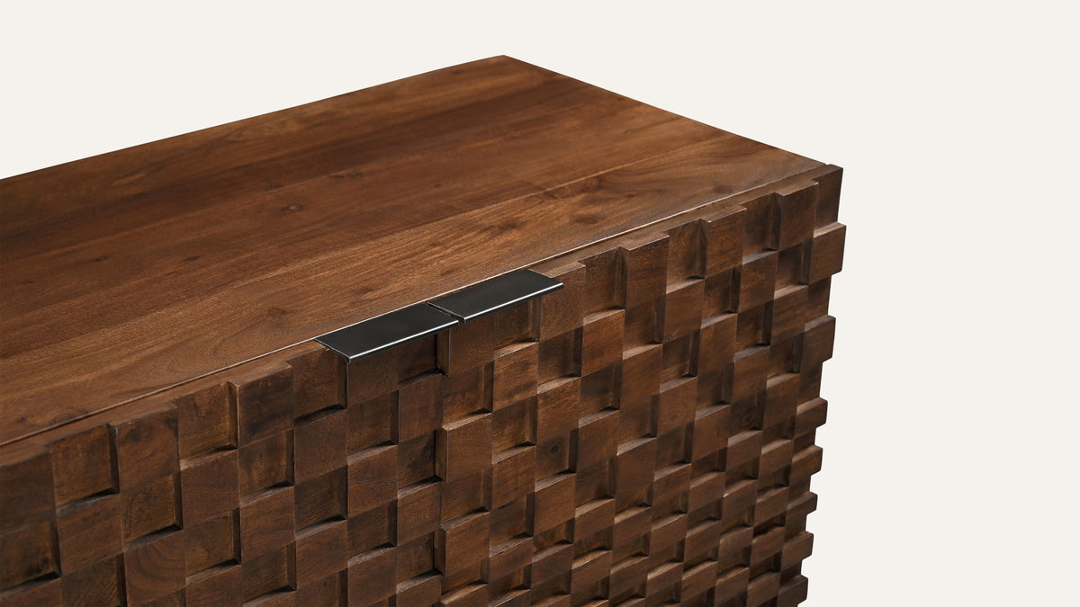 Close view of the Moe's Home Collection Easton sideboard corner, showing the acacia top edge and the three-dimensional blocks of the door front stepping in and out of shadow