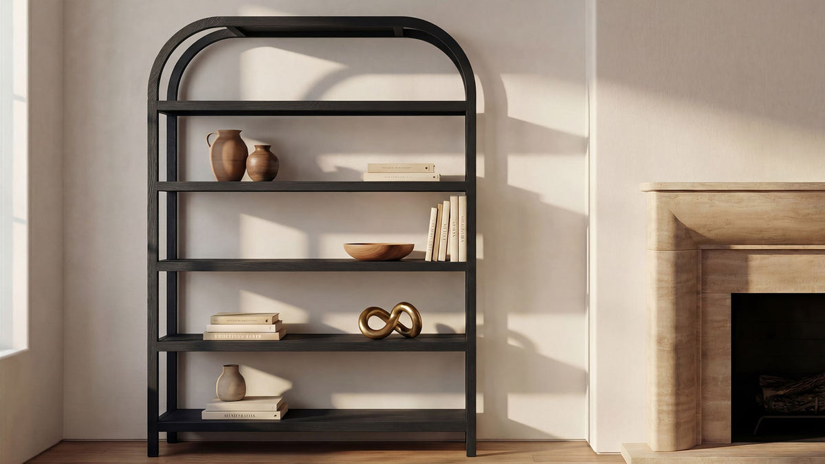 Moe's Home Collection Eero Large bookcase in black oak, five shelves in a wide arched frame beside a stone fireplace