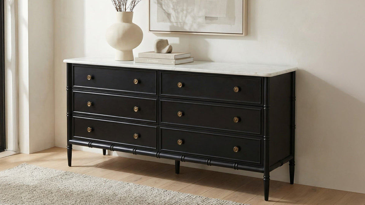 Moe's Home Collection Eleanor 6 Drawer Dresser in matte black with a white Banswara marble top, in a bedroom below framed art and a vase