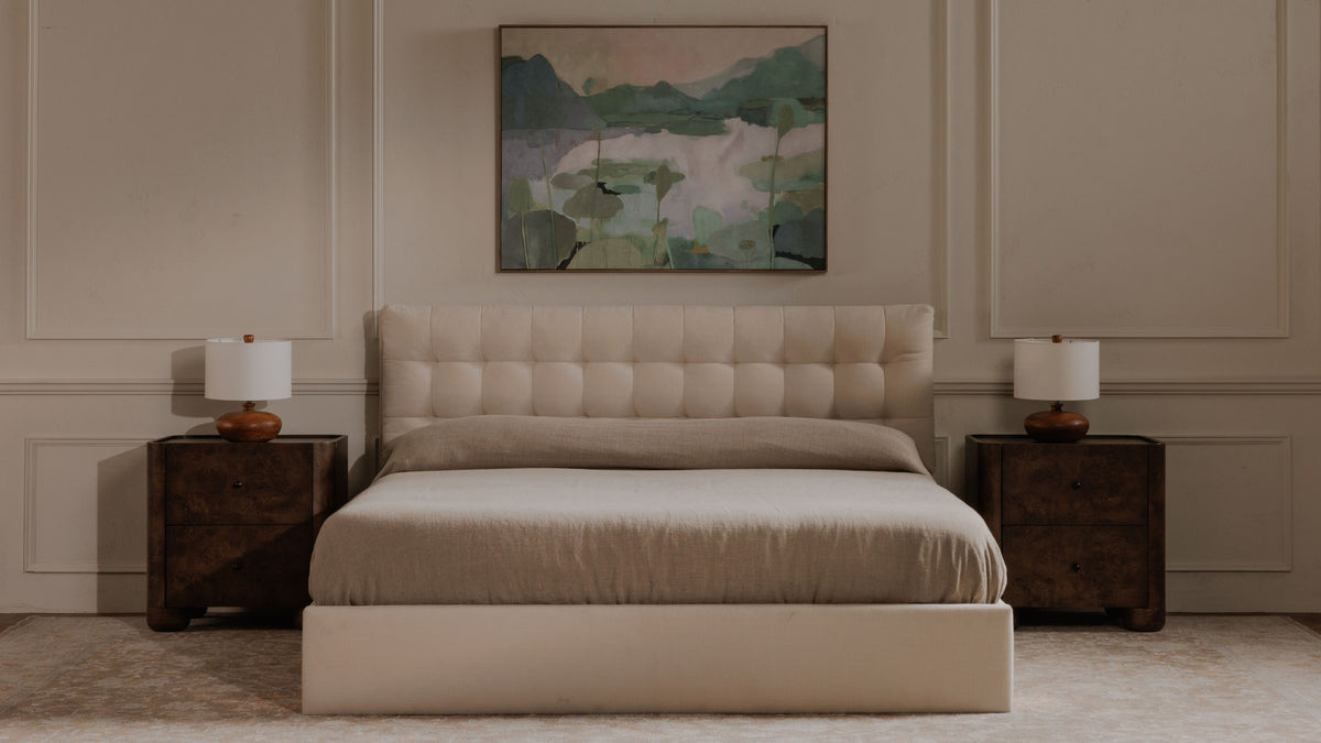 The same panelled bedroom with a pair of Moe's Home Collection Gibson nightstands in dark brown burl, their figured drawer fronts and rounded feet catching the light, each holding a turned wood lamp beside a cream tufted bed