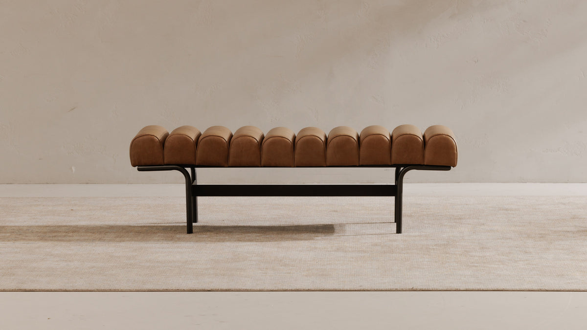 Moe's Home Collection Harrison bench in tan top-grain buffalo leather on a black iron frame, set against a pale plaster wall on a light rug