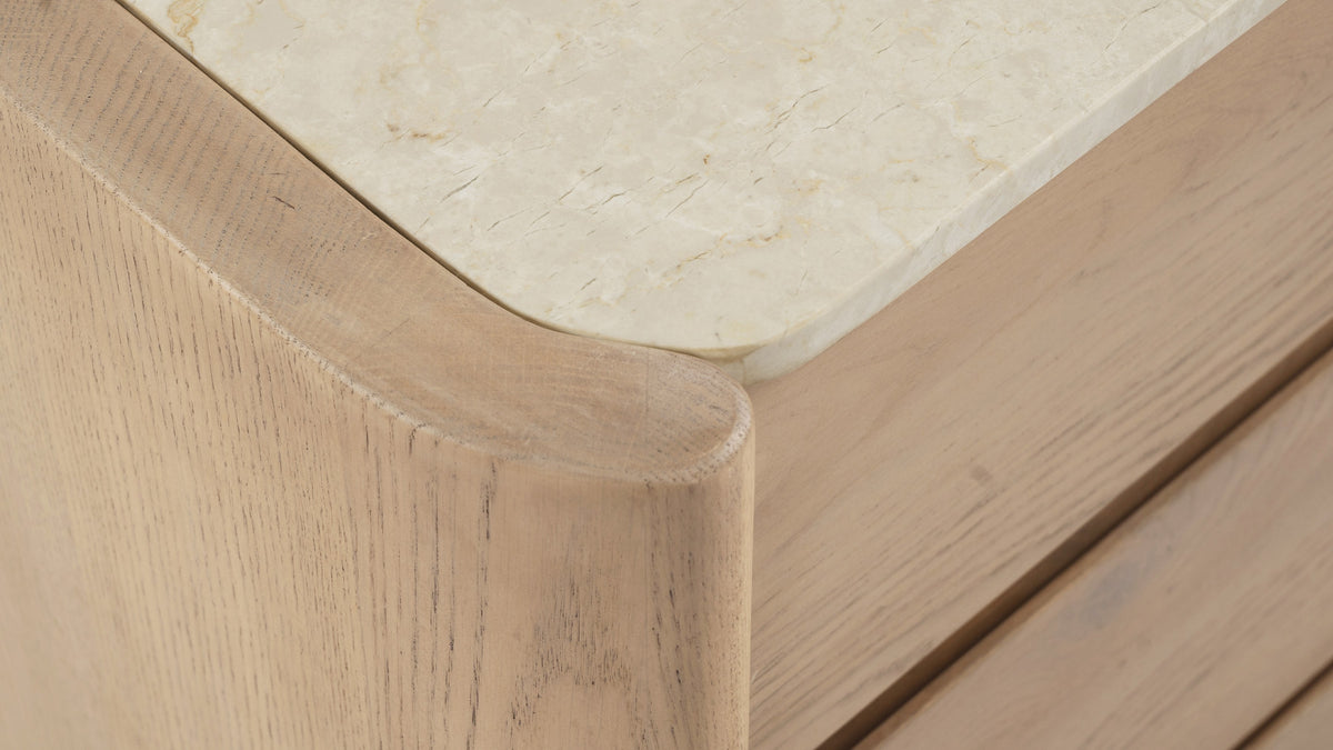 Close-up of the Moe's Home Collection Lane dresser: the inset Botticino marble top and its rounded overhang above the solid oak frame