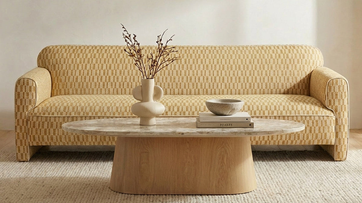 Moe's Home Collection Leo sofa in Light Brown, its single bench cushion and rolled arms reading terracotta against a plaster wall, behind a round dark oak coffee table on a faded patterned rug