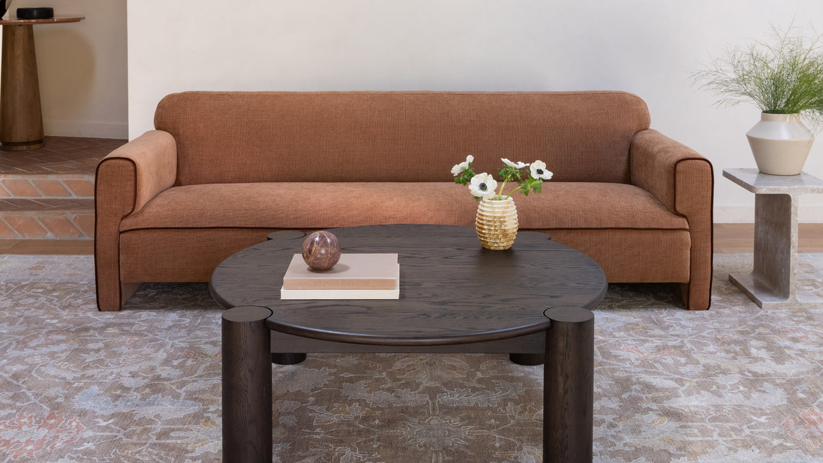 Moe's Home Collection Leo sofa in Chartreuse, its gold and cream checkerboard weave shown straight on in a bare plaster room, with an oval stone coffee table on a cream wool rug
