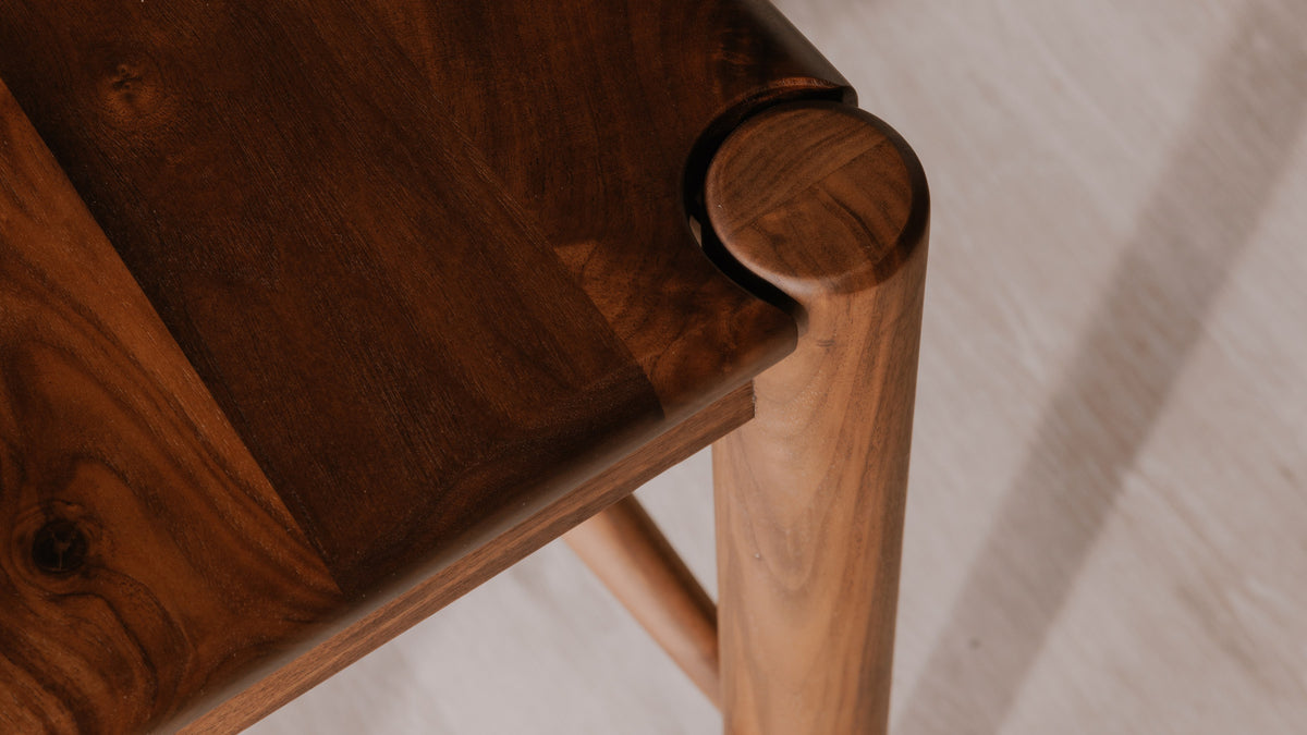 The Owing Counter Stool by Moe's Home Collection, solid walnut or solid oak with a curved open back, in a room setting