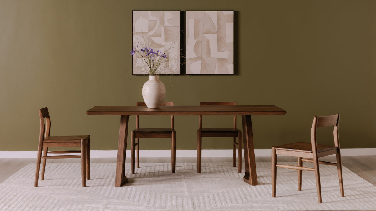 Four Moe's Home Collection Owing dining chairs in walnut brown around a walnut dining table against an olive green wall, with two abstract prints above and a cream rug underfoot