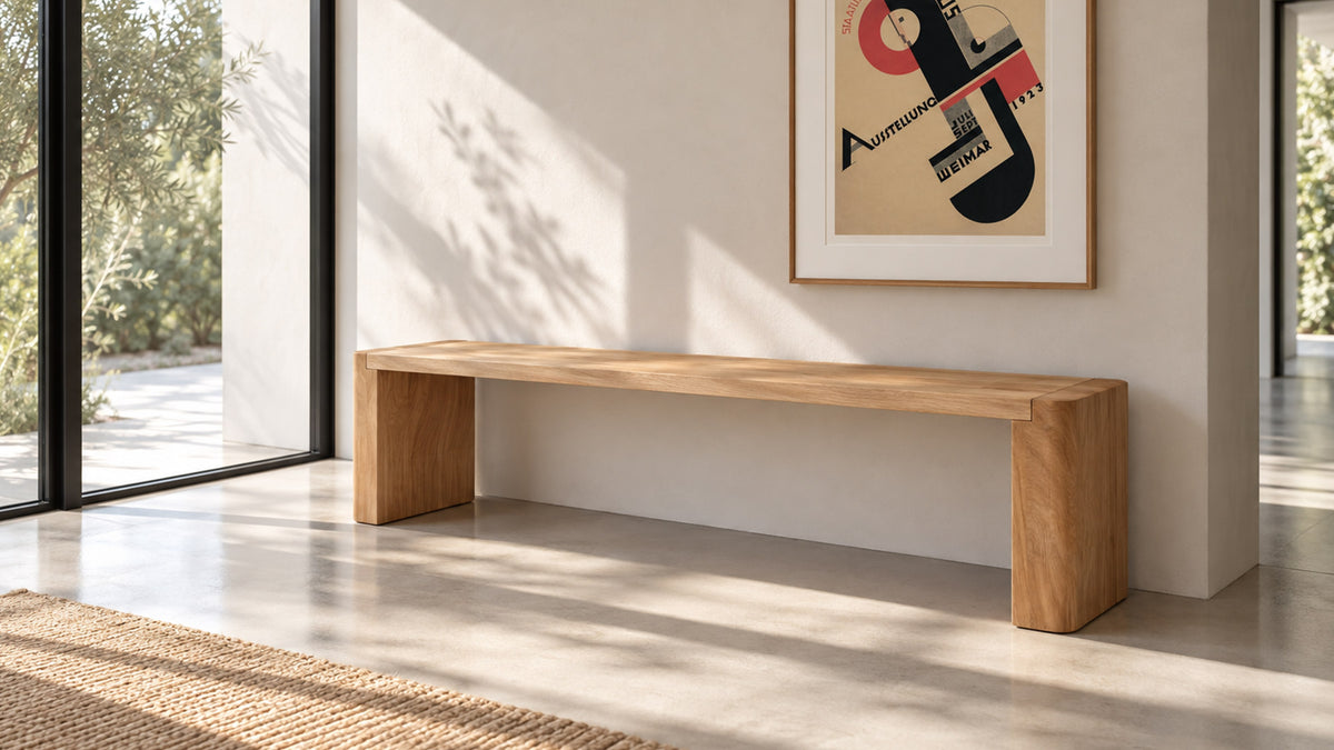 Moe's Home Collection Post dining bench in natural solid oak, a waterfall slab seat on two full-height legs, along a pale wall beneath framed artwork