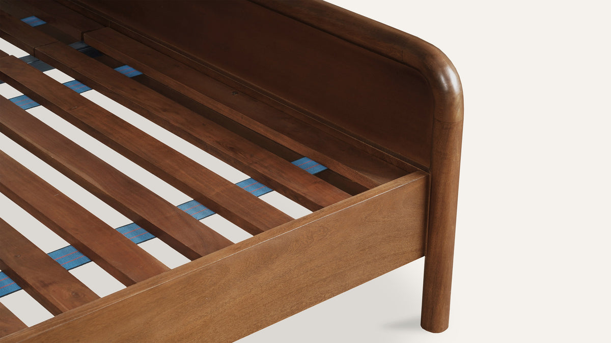 Close view of the Rye bed's wood slat support and the rounded corner where the side rail meets the footboard