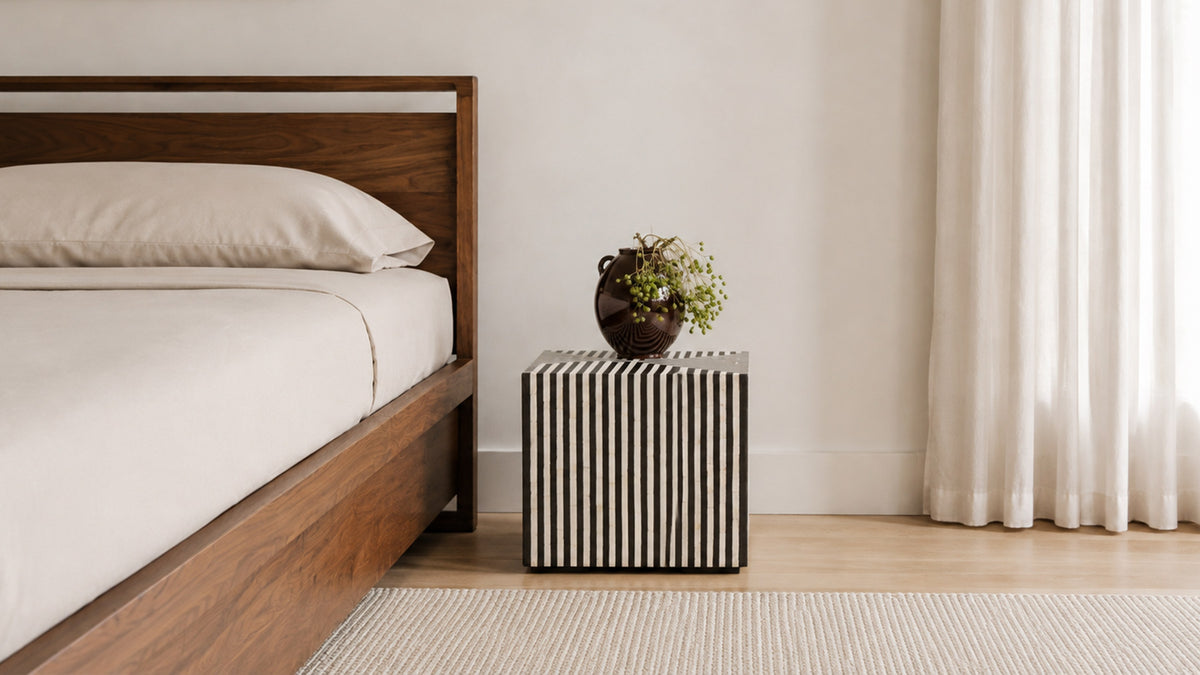 Moe's Home Collection Terning side table in black and white camel bone, its striped cube form beside a pale gray sofa on a wood floor, holding a white vase and a candle