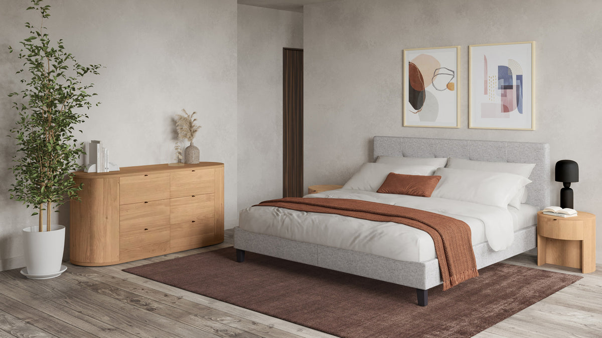 Moe's Home Collection Theo solid oak dresser in a bedroom, its rounded silhouette and six drawers with pull tabs against a plain wall