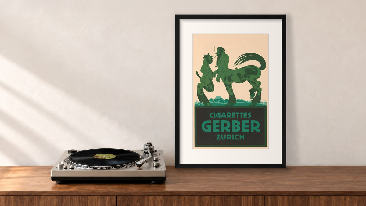 Cigarettes Gerber Zürich Framed Print in a black frame, leaning on a walnut console beside a turntable