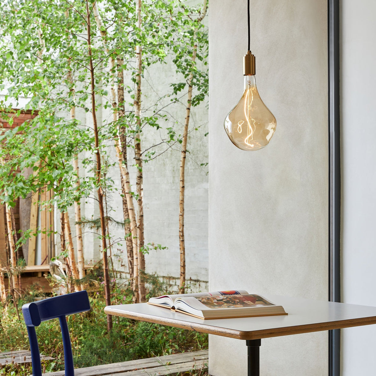 Voronoi II Pendant Light in Brass over a table by a window